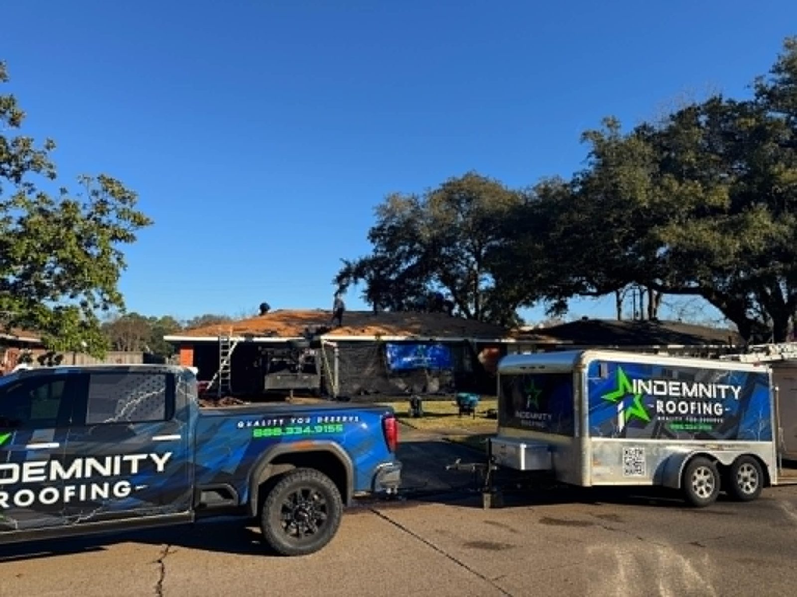 Indemnity Roofing branded truck and trailer at a roof replacement job in Shreveport-Bossier City