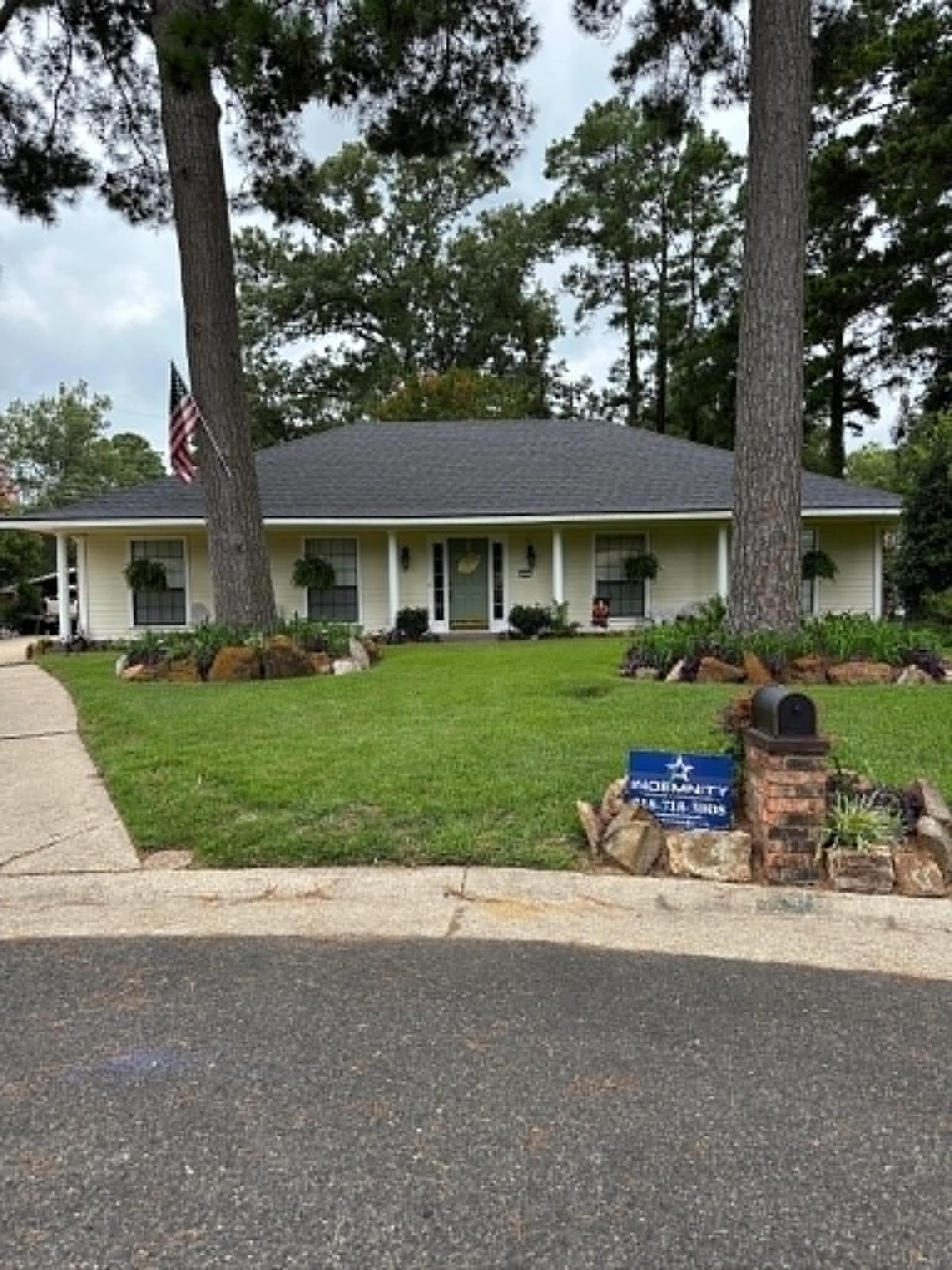 Completed roof with Indemnity Roofing yard sign in front of a Shreveport-Bossier home