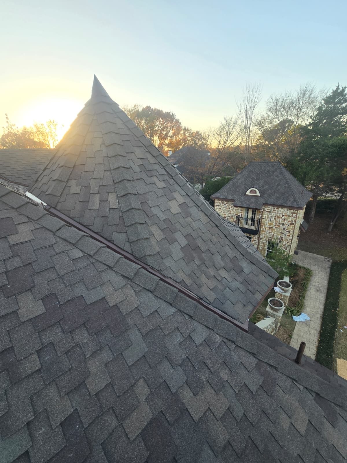 New architectural shingle roof at sunrise on a large home
