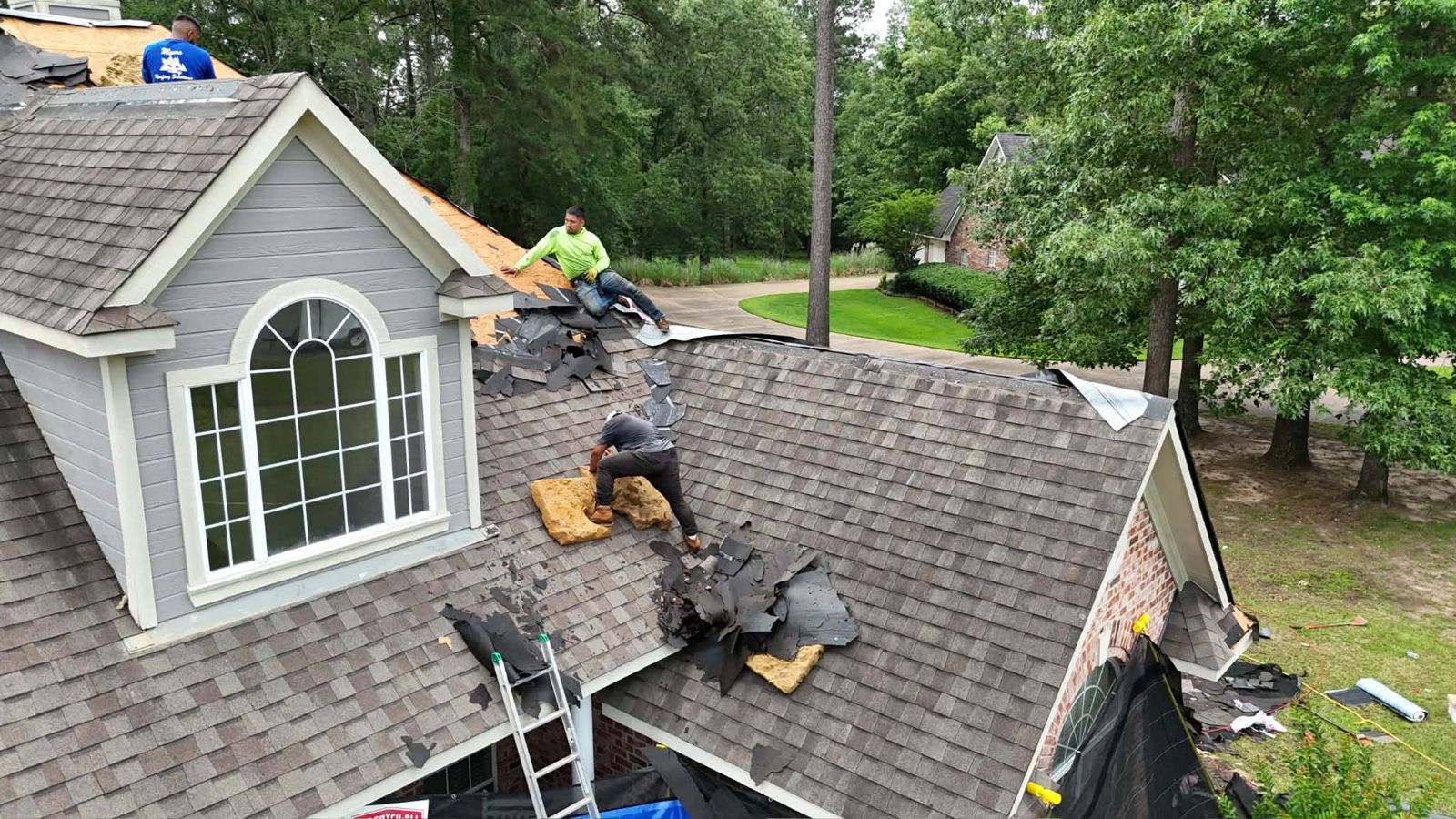 Indemnity Roofing crew tearing off old shingles down to the decking in Shreveport